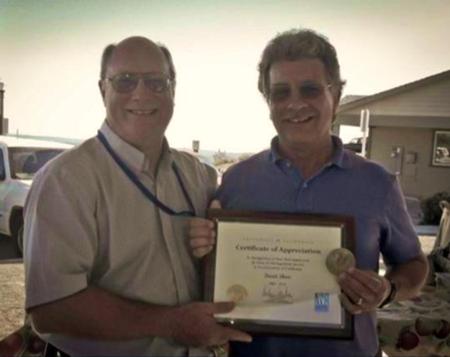 James Bethke (left) presents a plaque to Dave Shaw (right) in recognition of over 30 years of service to UC.